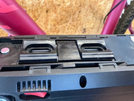 Rubber spacer pad under frame battery holder